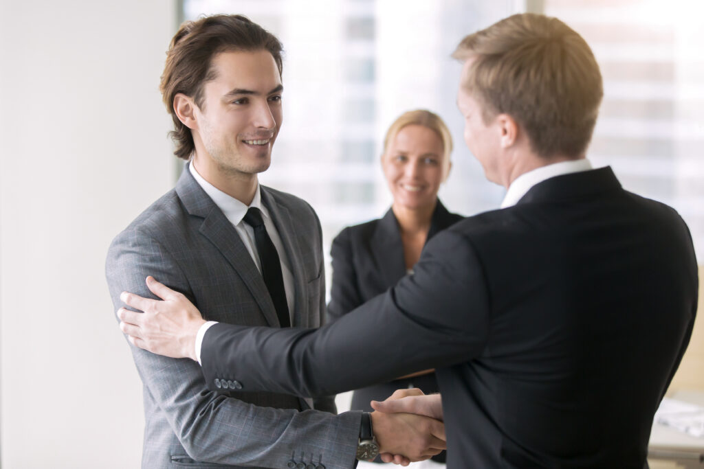 A sales professional congratulated by his mentor.